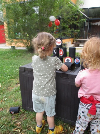 Zwei Kinder stehen vor dem Spiel Dosenwerfen.