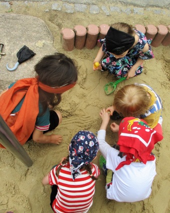 Die Kinder suchen Piratenschätze im Sandkasten.