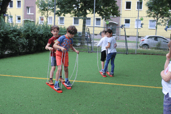 Kinder stehen zu zweit auf Skiern