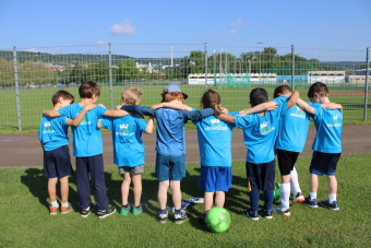 Kinder stehen Arm in Arm in einer Reihe.