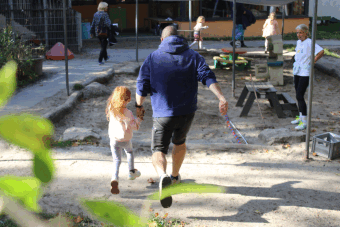 Kind und Eltern machen Weitsprung