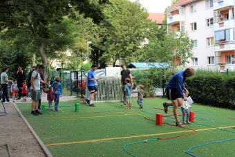 Kinder durchlaufen mit ihren Eltern einen Hindernislauf.