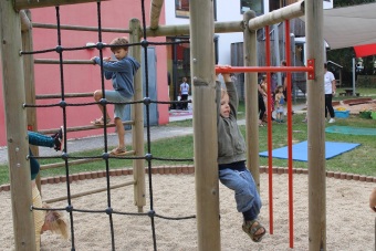 Kinder klettern auf einem Klettergerüst. 