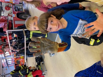 Kind zeigt Feuerwehrhandschuh