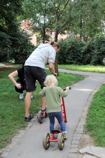 Ein Kind und sein Papa fahren mit dem Roller um die Wette.